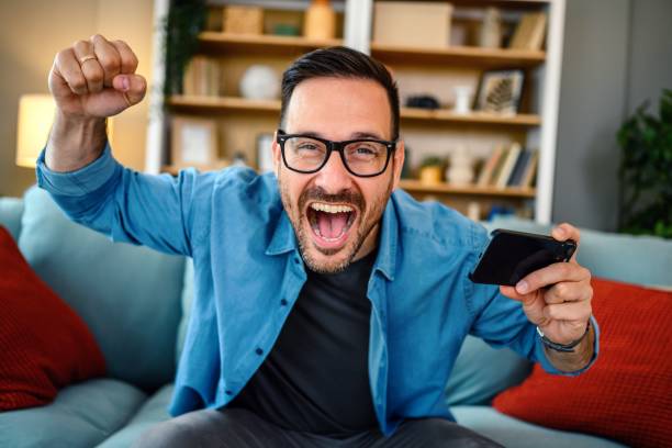 istock Happy man playing video games on his smartphone 1497858008
