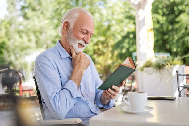 istock Senior man reading book and smiling 1497858427