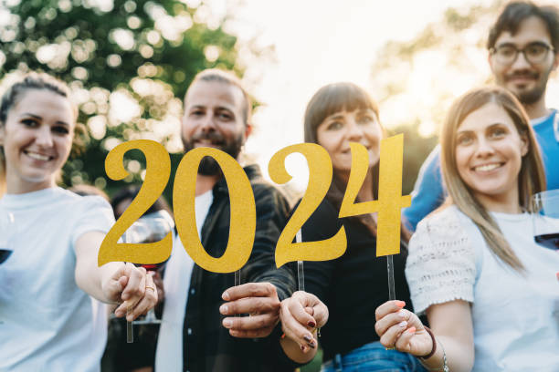 Happy friends are celebrating together the New Year Happy friends are celebrating together the New Year. They are holding 2024 text while they are drinking red wine together. 2024 30 stock pictures, royalty-free photos & images