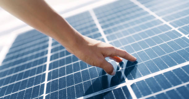 istock Hand of a woman touching a solar panel. Closeup of a construction worker installing renewable energy source on a roof 1497862698