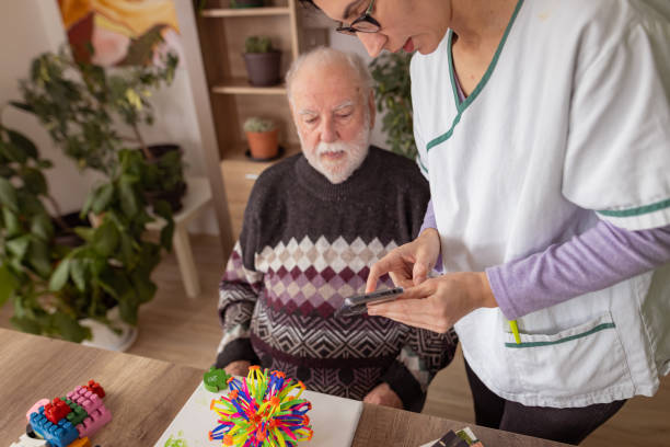 pokazywanie zdjęć na telefonie komórkowym w ramach terapii - alzheimers disease brain healthcare and medicine aging process zdjęcia i obrazy z banku zdjęć