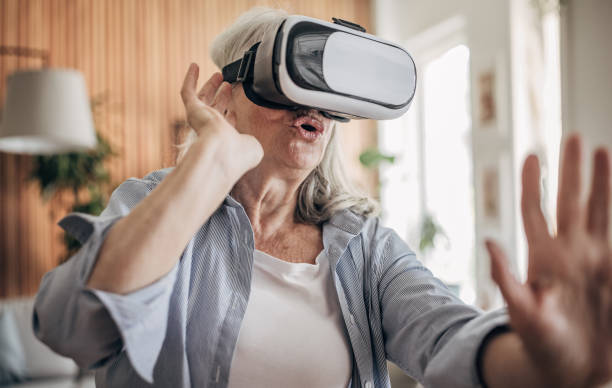 istock Senior woman having fun with vr glasses at home 1497864186
