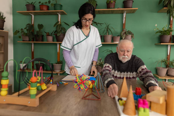 istock Senior man with dementia engages in sensory play during therapy session 1497864304