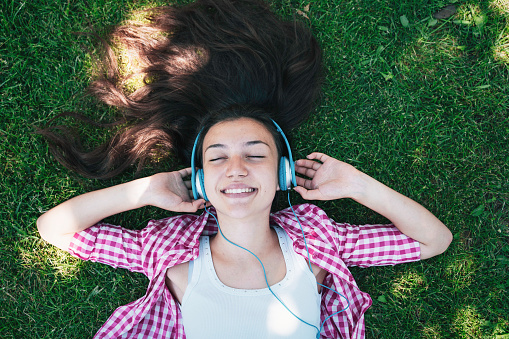Teenage girl with headphones listening music.
