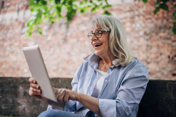 istock Senior woman using digital tablet and relaxing in the backyard 1497866847
