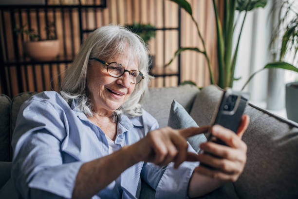 istock Senior woman sitting at home and using smartphone 1497868307