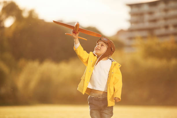 istock Toy plane. Little boy is playing on the summer field 1497868352