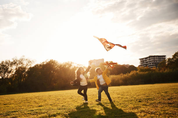istock Two kids are playing with kite on the summer field 1497868562