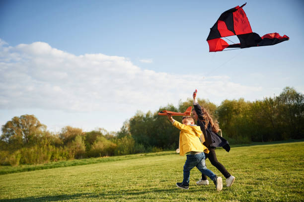 istock Clear sky. Two kids are playing with kite on the summer field 1497868578