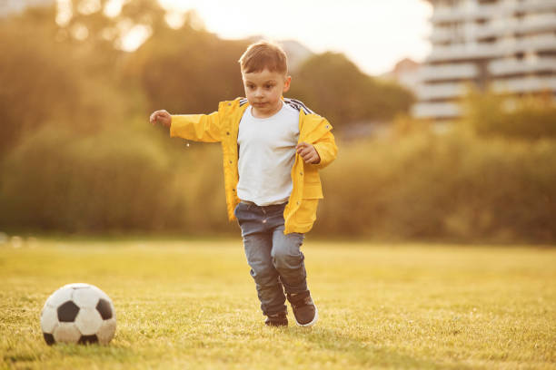 istock Front view. Boy is on the summer field with soccer ball 1497868692