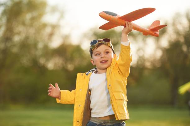 istock Focused view with background. Little boy is playing with toy plane on the summer field 1497868764