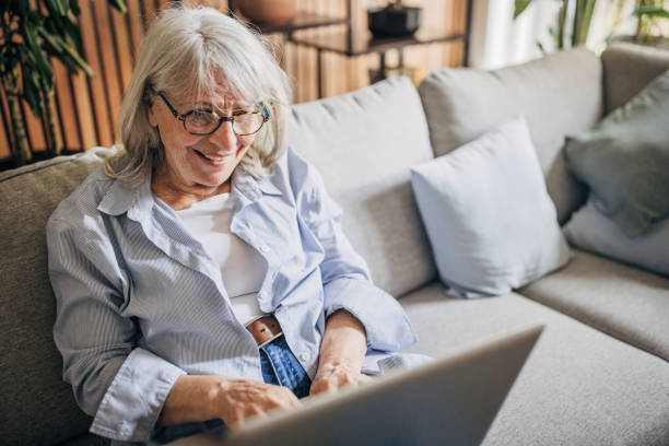 istock Senior woman using laptop at home 1497869369