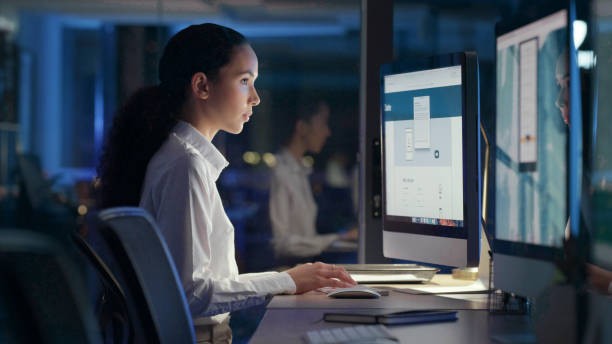 istock Business woman typing emails, browsing the web and meeting a deadline while working overtime in a dark office alone. Black female, professional and manager doing research online on the web at work 1497871939