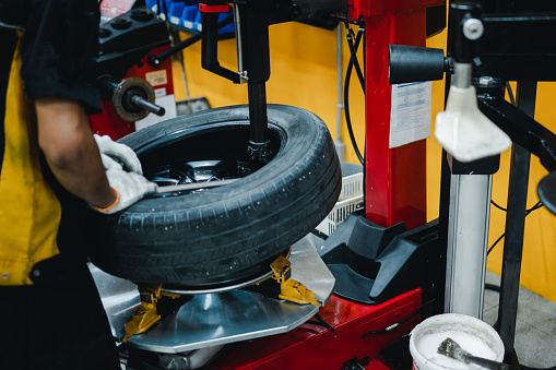 Mechanic changing tires on tire changer in auto service center. Concept maintenance service and checking, 
Checks the mileage of the car.