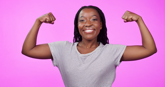Portrait, smile and black woman flexing muscle in studio isolated on a purple background. Power, strong and African female person flex bicep arm for feminine empowerment, confidence and hard work.
