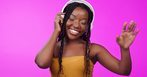 Music, headphones and happy black woman isolated on studio background. Freedom or happiness, entertainment and African female woman listening to podcast or radio for youth confidence with headset