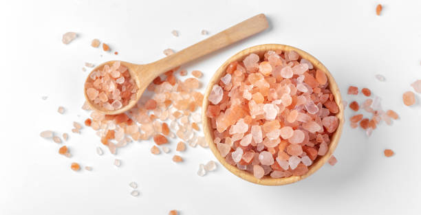 himalayan pink salt in wooden bowl with spoon on white background - pink salt imagens e fotografias de stock