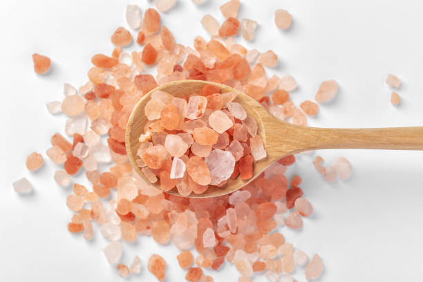 istock Himalayan pink salt in wooden spoon on white background 1497882330