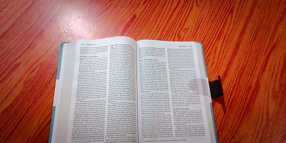 Selective focus view of an open Bible on a table.