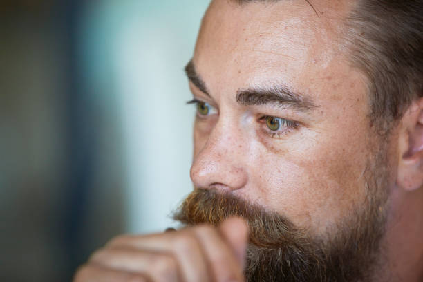 Closeup of a businessman with beard sitting and listening in on business meeting