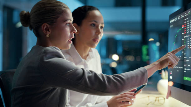 profissionais de negócios, finanças e economia olhando para as receitas financeiras e despesas da empresa em uma tela de computador. comerciantes mulheres trabalhando e colaborando horas extras para cumprir um prazo - scrutiny analyzing finance data - fotografias e filmes do acervo