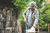 mature adult man chopping wood in the yard