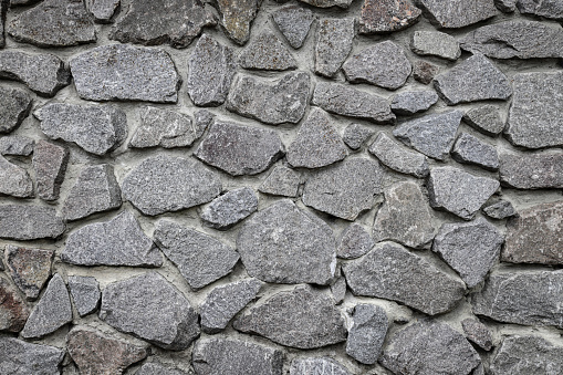 Gray stone wall texture. Wide panoramic rock pattern. Natural masonry surface, brick frame. Grey wall background grunge texture. decorative uneven cracked real stone structure. Design element.