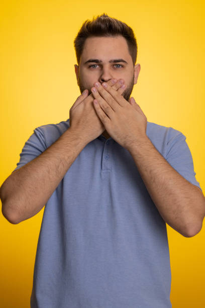 istock Frightened scared man closing his mouth with hand, gestures no, refusing to tell terrible secret 1497898213