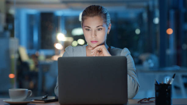 istock Serious business executive working late night on laptop reading email or working on analytics report alone in modern office. Corporate female manager or workaholic with a deadline working after hours 1497900835