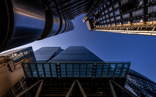 London, UK: Looking up at skyscrapers in the City of London. Cheesegrater (front) and Lloyds building (top). Evening view from Leadenhall Street.