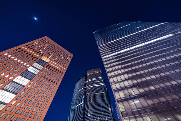 angolo basso del centro della città di shiodome di notte nella zona shiodome di minato, tokyo, giappone - shimbashi district skyscraper building exterior low angle view foto e immagini stock