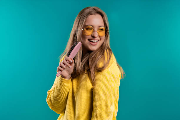 istock Woman singing, dancing with hair brush instead microphone on blue background 1497906607