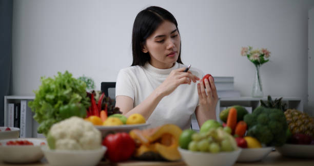 istock Young female Nutritionist check nutritional value of fruit and vegetable 1497907514