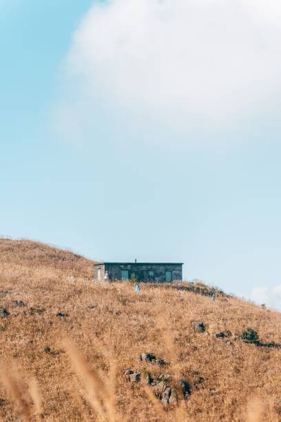 istock a building on a hill surrounded by tall grass and sky 1497907772