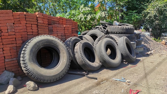 Old used tire in after being used by truck in junkyard