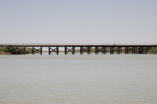 Wooden bridge over the river Tigris in Southern Iraq with the river in the for-ground in daylight