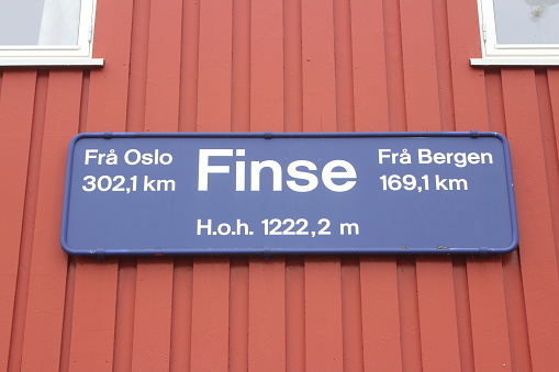 Finse. Norway. Hardanger Vidda. A sign at a wall shows Finse with 1222 metres above sea level as the most highest railway station in whole Scandinavia. In Finse you can find the station, a hotel and some houses for the railway workers. One can reach Finse only by train or hiking for many hours on a small path alon the railway track. In Finse stop the trains on the line Oslo-Bergen, the famous Bergenbahn/Bergen Railway.