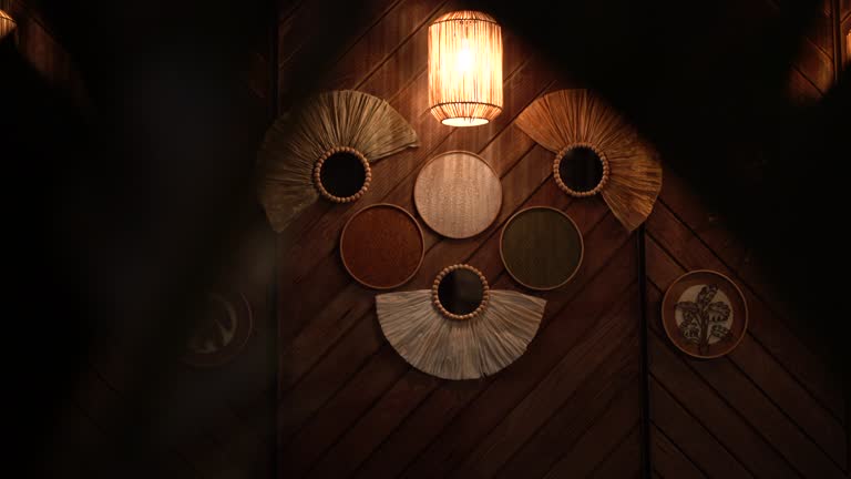 Decorative rustic mirrors and wicker lamp hanging on wooden wall