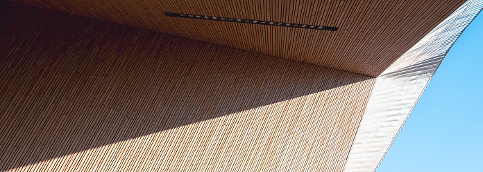 A low angle of a wooden ceiling of a building exterior with the