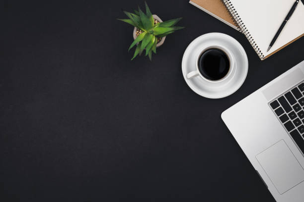 istock Laptop, coffee cups and notepads on a black background, top view. 1497921803