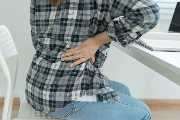 istock woman holding her lower back while and suffer from unbearable pain health and problems, chronic back pain, backache in office syndrome, scoliosis, herniated disc, muscle inflammation 1497921864