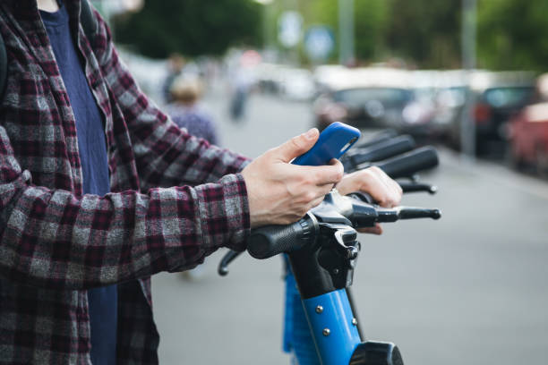 istock Close up of man hand using mobile app for rental electric scooter. 1497926321