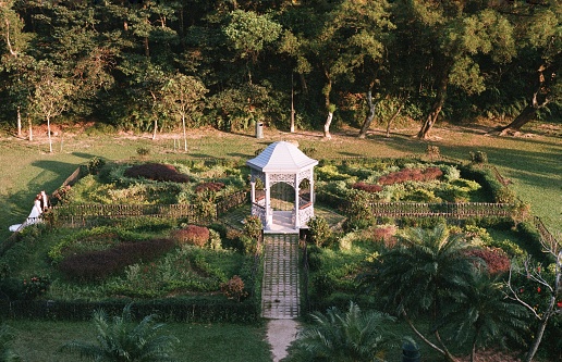 An aerial view of a lush green garden with a gazebo and trees in the distance in Hong Kong