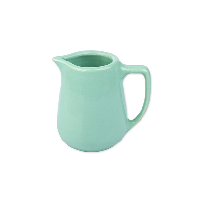 Light green ceramic milk pitcher isolated over white background.