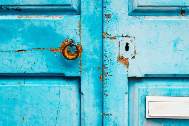 istock A weathered turquoise door with metal lock. 1497937621