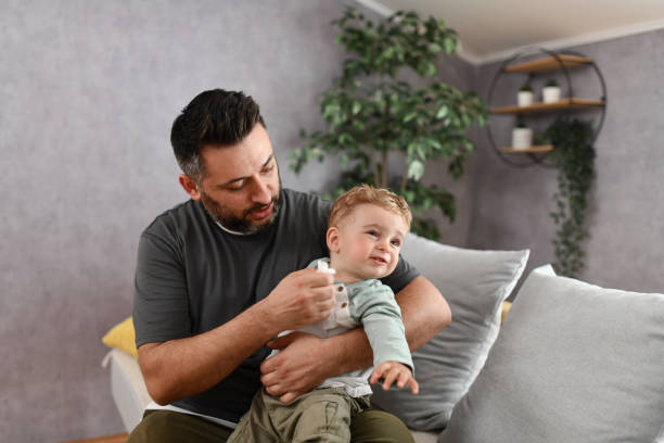 istock Caring Father Puts Napkin On Baby Boy's Face While Sneezing 1497938240