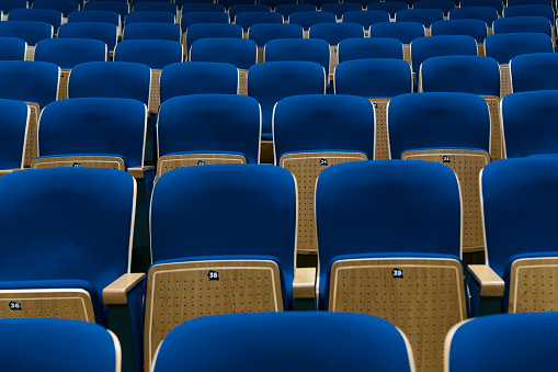 row of blue plastic seats in a stadium