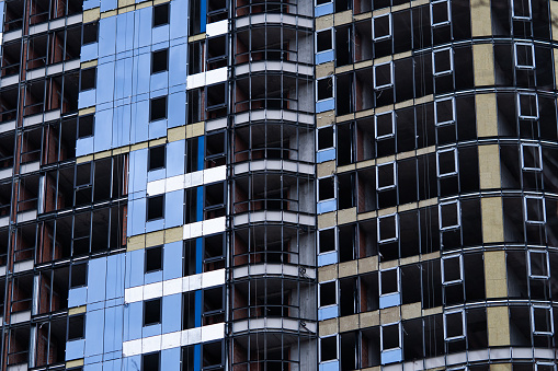 Facing the building with a ventilated facade. Aluminum colored facades. Modern facades of high-rise buildings. Construction of a large residential complex.