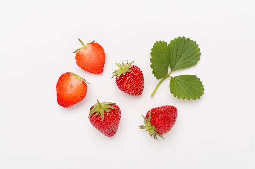 Strawberries with leaves on white background, top view