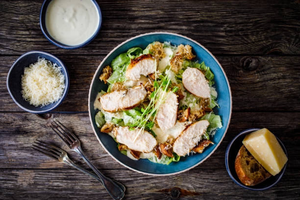 istock Caesar salad  - vegetable salad with roast chicken breast on wooden table 1497943525